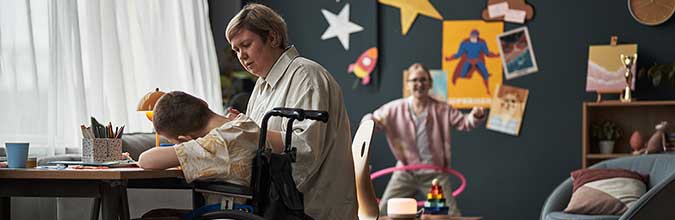 Begeleider ondersteunt kind in rolstoel tijdens creatieve activiteit in een zorginstelling