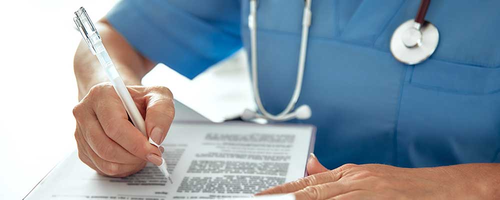 Verpleegkundige schrijft rapportage tijdens personeelsplanning in de zorg